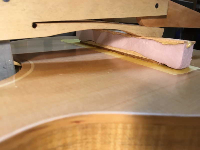 Gluing laminated bridge to Sitka Spruce top using cam clamps and plywood/foam cauls
